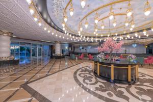 a large lobby with a large chandelier and a table at Lake River Side Hotel Spa in Side +37 photos