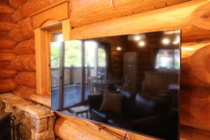 a large flat screen tv on the wall of a log cabin at ログキャビン伊豆高原 in Futo