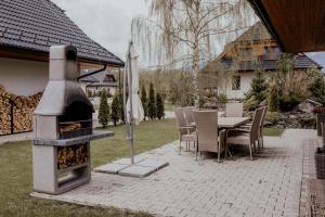 eine Terrasse mit einem Tisch und einem Backofen im Freien in der Unterkunft Chata HOME Stará Lesná in Stará Lesná