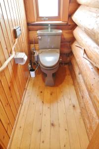 - une salle de bains avec toilettes dans une cabine en bois dans l'établissement ログキャビン伊豆高原, à Futo