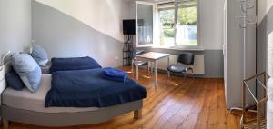 una camera da letto con letto con lenzuola blu e scrivania di Monteurs Zimmer Noack a Börßum