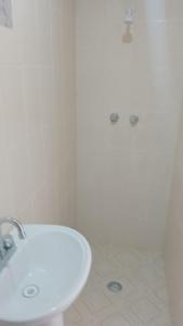 uma casa de banho branca com um lavatório e um chuveiro em El Rincón del Ángel Tuxpan em Tuxpan de Rodríguez Cano