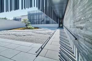 um corredor de um edifício com uma árvore nele em MUNI KYOTO by Onko Chishin em Quioto