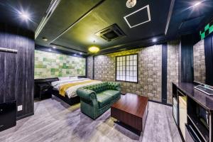 a bedroom with a bed and a couch at Hotel Lotus Gorgeous Japan Kyoto -Adult Only in Kyoto
