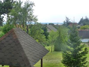 um telhado de telha no topo de um campo com uma árvore em House Elisabeth Balaton em Vonyarcvashegy