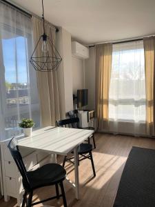 a dining room with a white table and chairs in a room at Modern holiday apartment Vilnius in Vilnius