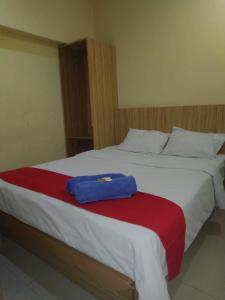 uma cama com um cobertor vermelho e branco em Hotel Mayang Sari 1 em Jambi