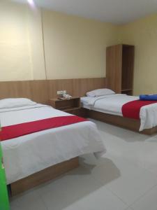 a hotel room with two beds with red and white sheets at Hotel Mayang Sari 1 in Jambi +4 photos