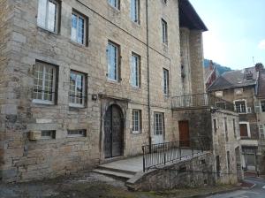 ein großes Steingebäude mit einer Tür und einer Treppe in der Unterkunft O'Couvent - Appartement 44 m2 - 1 chambre - rdc ext in Salins-les-Bains