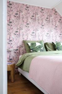 una camera con un letto a scomparsa rosa di het opgemaakte bed a Haps