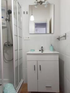 La salle de bains blanche est pourvue d'un lavabo et d'un miroir. dans l'établissement Villa Daita 2 Villa Daita 3, à Granadilla de Abona