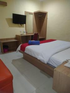 a bedroom with a bed with a laptop on it at Hotel Mayang Sari 1 in Jambi