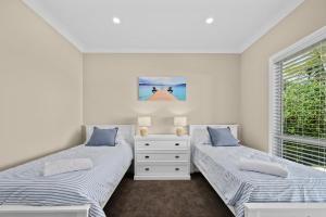 two beds in a white room with a window at Wauwa-ana - Moana - C21 SouthCoast Holidays in Moana