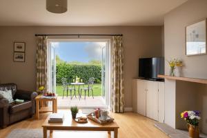 a living room with a door open to a patio at Chase Lodge, Kenilworth, Family Sized Cottage With free Wifi in Kenilworth