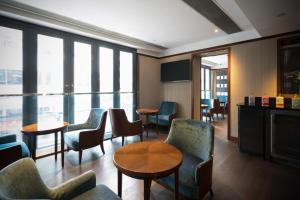una sala de espera con sillas, mesas y ventanas en Hotel One Eighteen, en Hong Kong