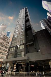 um edifício alto com pessoas a andar na frente dele em Hotel One Eighteen em Hong Kong