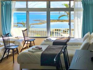 a hotel room with two beds and a large window at Azama Ocean View Terrace in Azama