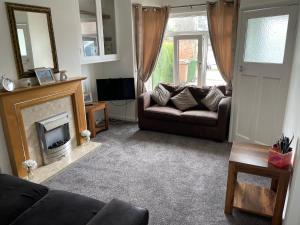 a living room with a couch and a fireplace at No 6 Chestnut Grove in Withernsea