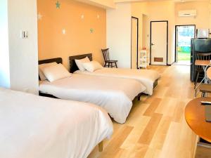 pokój hotelowy z 3 łóżkami i stołem w obiekcie Azama Ocean View Terrace w mieście Azama