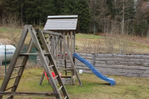 un parque infantil con un tobogán azul y una estructura de madera en Apartement 270 Mitterdorf en Mitterfirmiansreut