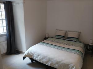Ce lit se trouve dans une chambre blanche dotée d'un couvre-lit blanc. dans l'établissement O'Couvent - Appartement 54 m2 - 1 chambre - A301, à Salins-les-Bains