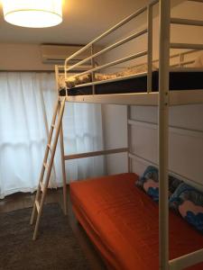 a room with two bunk beds and a lamp at it senriyama 101 in Senriyama