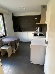 a kitchen with white cabinets and a stove top oven at Amazing appartment in the middle of the nature in Silenen