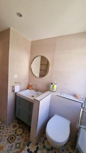 ein Badezimmer mit einem WC, einem Waschbecken und einem Spiegel in der Unterkunft Appartement bord de mer in Cannes