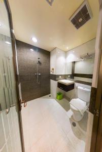 a bathroom with a shower and a toilet and a sink at Grand Madani Hotel in Mataram