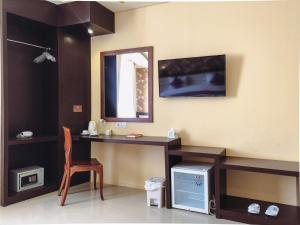 Una televisión o centro de entretenimiento en Grand Madani Hotel
