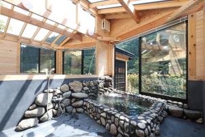 una piscina en una casa con una pared de roca en 古民家ー芦ヶ久保 en Chichibu