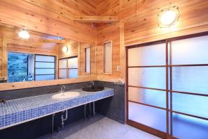 秩父市にある古民家ー芦ヶ久保の洗面台付きのバスルーム、木製の壁