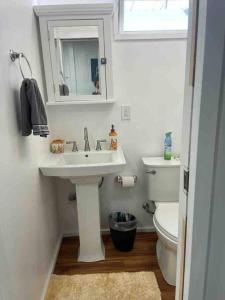 Baño blanco con lavabo y aseo en Tavares house, en Waialua