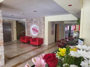 a waiting room with red chairs and flowers at Das Hostal in El Arenal