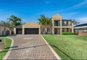 a large house with a driveway in front of it at Beautiful 5 bedroom house in Jervis Bay in Sanctuary Point