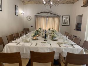 une grande table avec un tissu de table blanc et des chaises dans l'établissement Don Pasquale Picciano- PESCARA-ABRUZZO, à Picciano