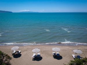 un gruppo di sedie e ombrelloni in spiaggia di Residence Pineta ad Albinia