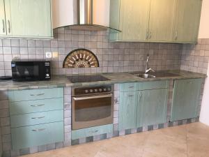 a kitchen with blue cabinets and a sink at Rooms Hrominc in Bled