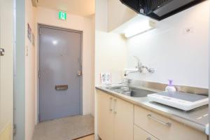 a kitchen with a sink and a door to a bathroom at it senriyama 203 in Senriyama +23 photos