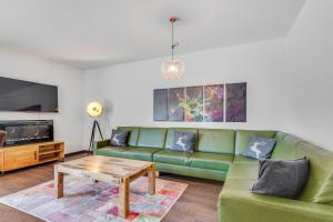 - un salon avec un canapé vert et une table basse dans l'établissement STANTON Lodge, à Sankt Anton am Arlberg