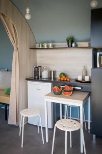 佩羅訥的住宿－Les Insolites du Brochet，一个带桌子和两张凳子的小厨房