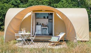 a tent with a table and chairs in a field at Les Insolites du Brochet in Péronne