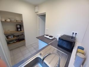 uma cozinha com um lavatório e uma bancada em La Cense Hebron em Ardres