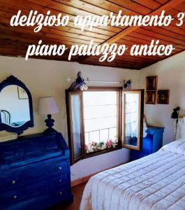 een slaapkamer met een bed, een spiegel en een raam bij Appartamento “Il Borgo” in Peccioli