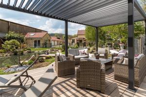 Aubigny-lès-SombernonにあるLes Gîtes du Griffon l'Erableの籐の椅子とパーゴラ付きのパティオ