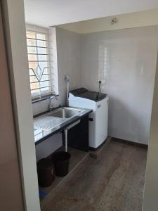 a small kitchen with a sink and a refrigerator at Castle BGR in Bangalore