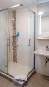 a bathroom with a shower and a sink at Hotel Am Uenglinger Tor in Stendal
