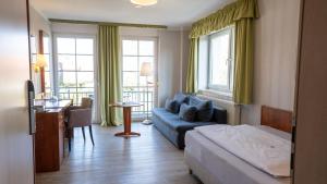 ein Hotelzimmer mit einem Bett und einem Sofa in der Unterkunft Hotel Am Uenglinger Tor in Stendal