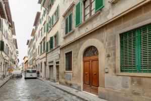 a building with a wooden door on a street at Turandot Apartment by Mamo Florence in Florence