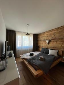 ダボスにあるWEF 2026 Ferienwohnung, 1min von Kongresshausの木製の壁と大きなベッドのある寝室